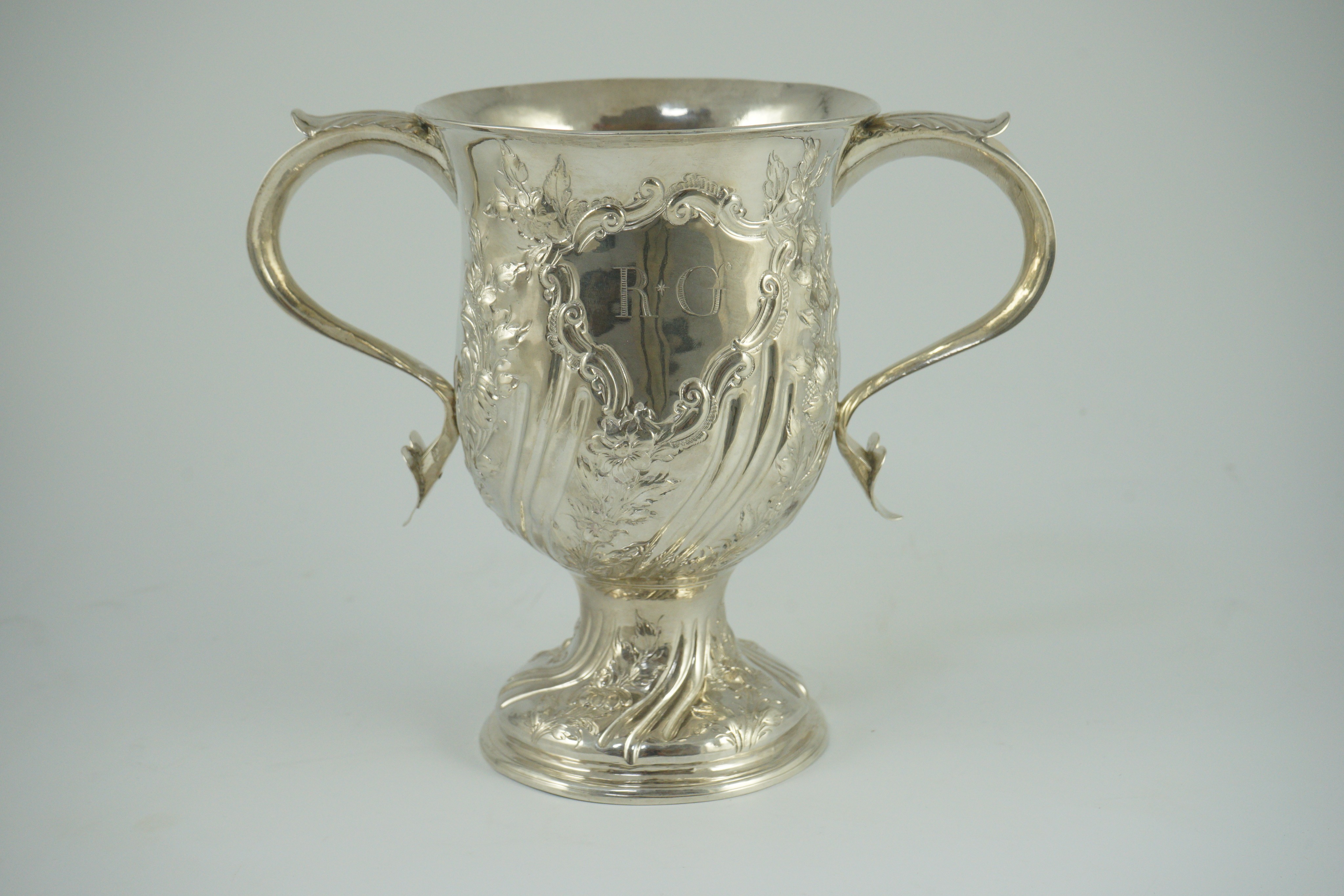 A George III silver baluster two handled pedestal cup, with later embossed decoration, by John Scofield